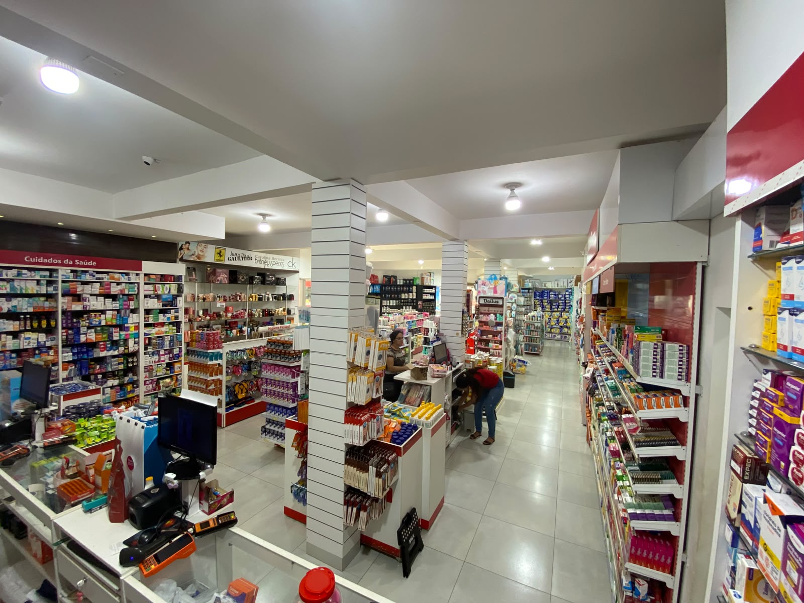 Interior da farmácia com prateleiras e balcão